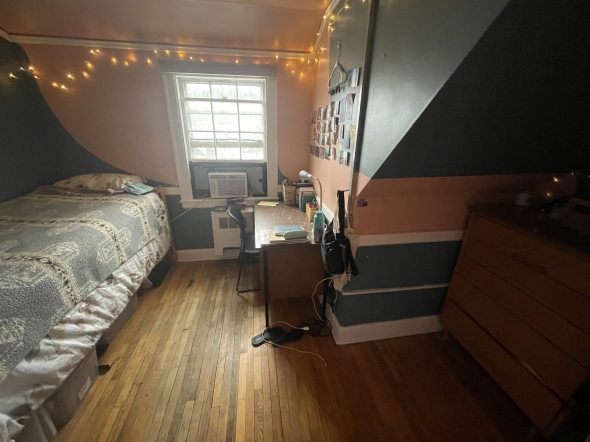 a picture of Kalina's room in alpha theta - there's a bed to the left, a desk to the right, and the walls are teal-peach colored