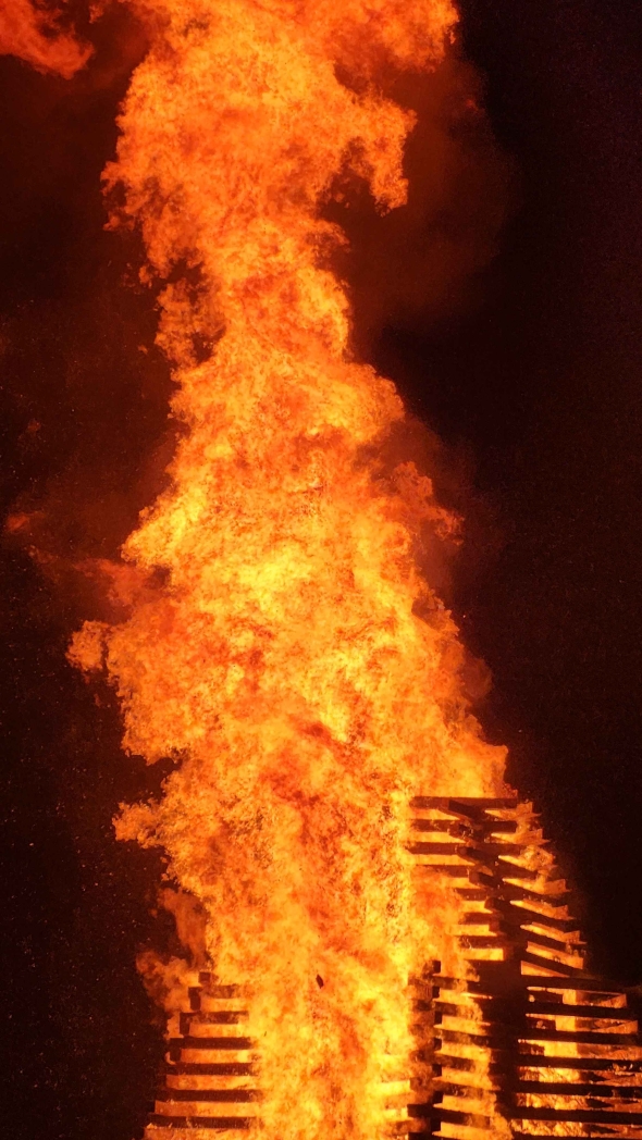 A picture of flames part of a massive, tall bonfire