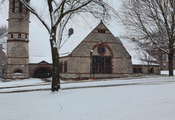 A photograph of a snowy landscape with a chapel and some trees