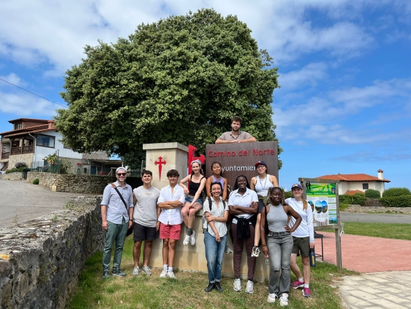 A group photo on next to a sign for the Camino de Santiago