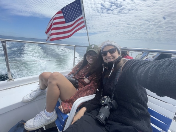 a picture of Diana and Kalina on a boat with the ocean and the american flag in the background