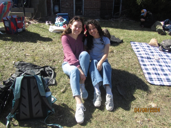 Two girls sitting on a grassy hill