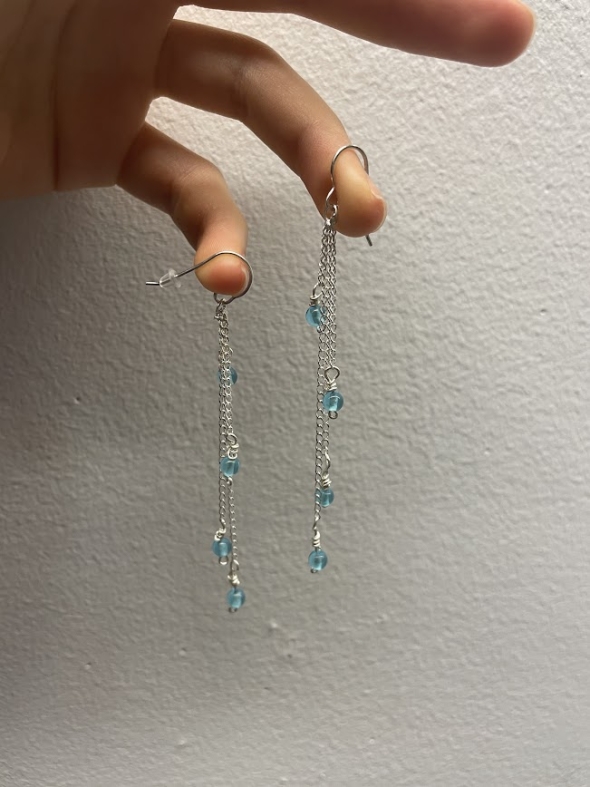 a picture of the earrings Kalina made, hanging from her two fingers