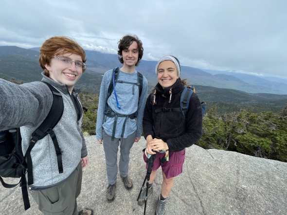 a picture of Owen, Levi and Kalina on top of mount kinsman