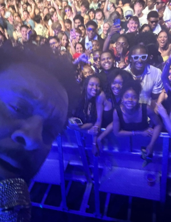 A selfie of Shaggy facing the crowd of students in the front row of the concert.