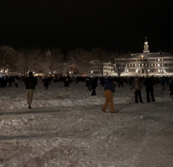 A picture of the Dartmouth Green with groups of people playing in the snow during the snowball fight.