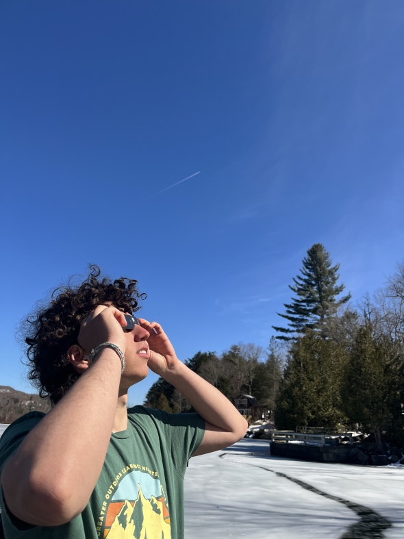 A photo of my friend, Adam, watching the eclipse with his glasses!