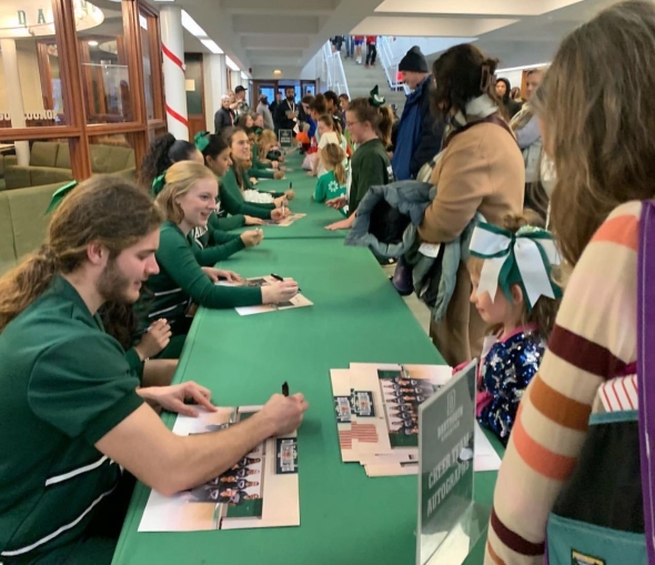 The cheer team signing autographs post-game at the end of Youth Cheer Day.