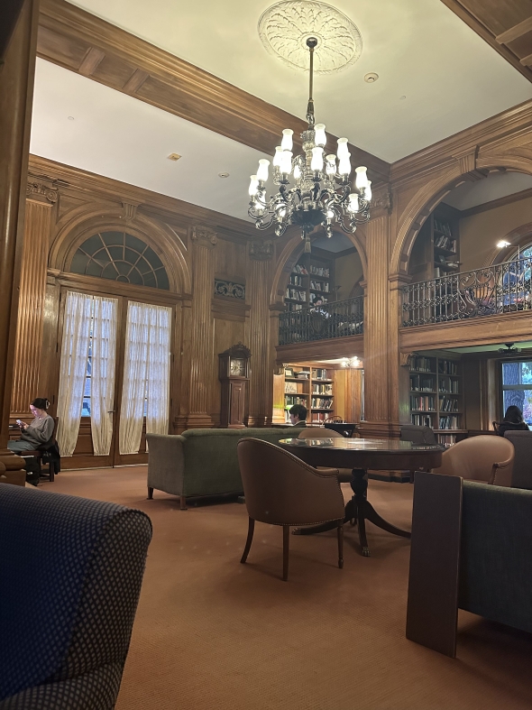 Picture of a wooden library with a chandelier. 