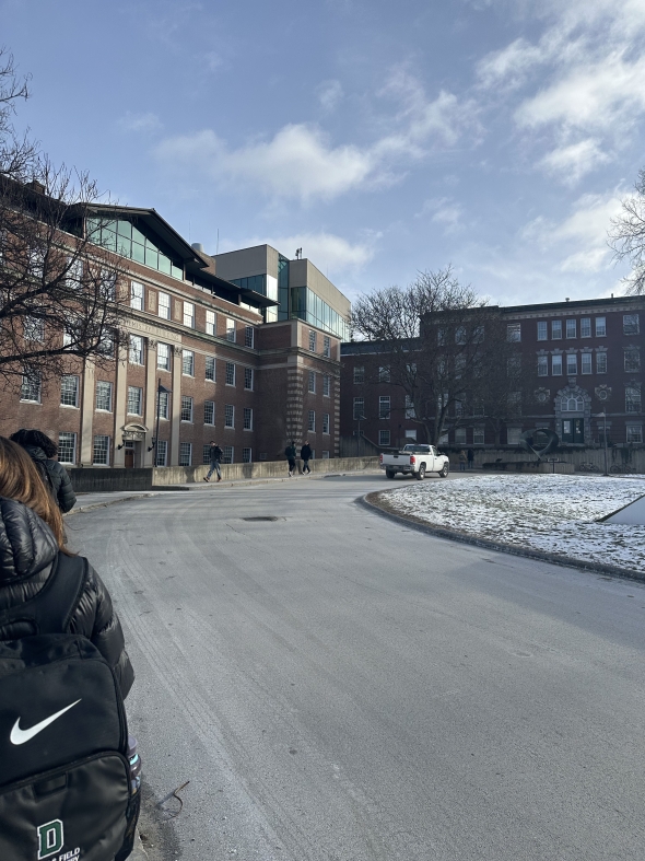 Picture of brick building with students walking towards it.