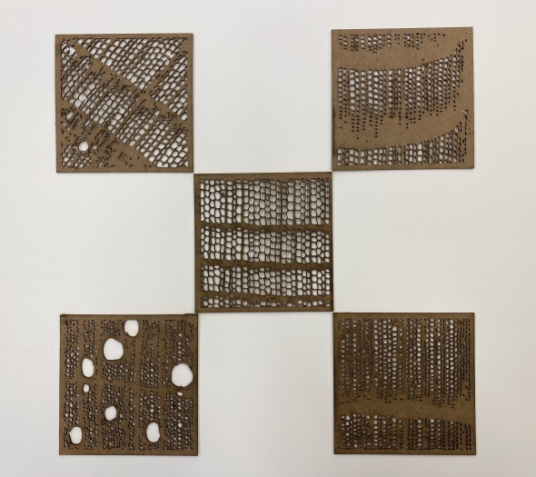 Laser-cut cardboard tiles of microscopic wood structures.