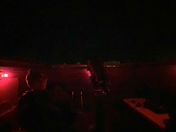 A dark view of the observatory lit by red night lights. 