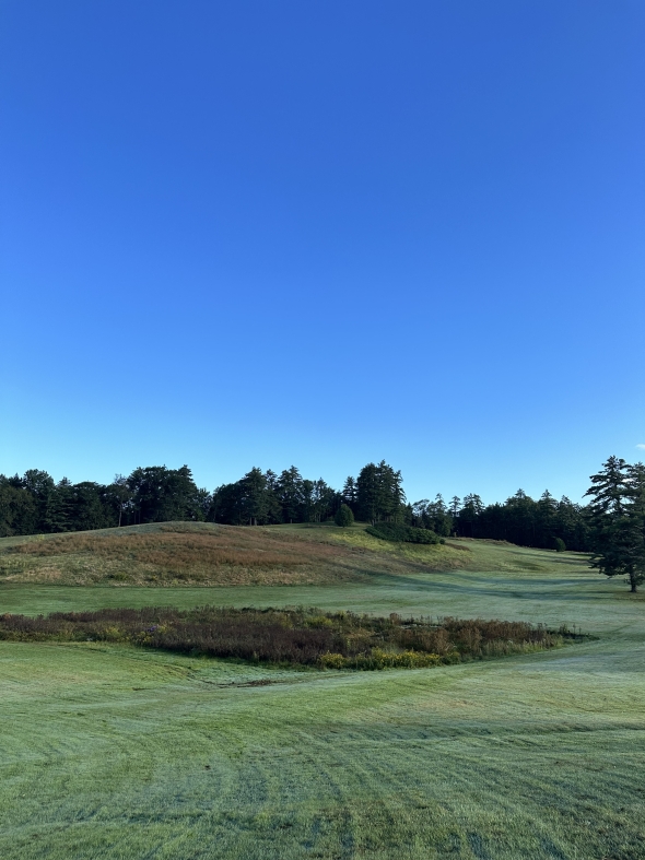 Dartmouth's expansive golf course, displayed with green grass and a deep blue sky in the late summer.