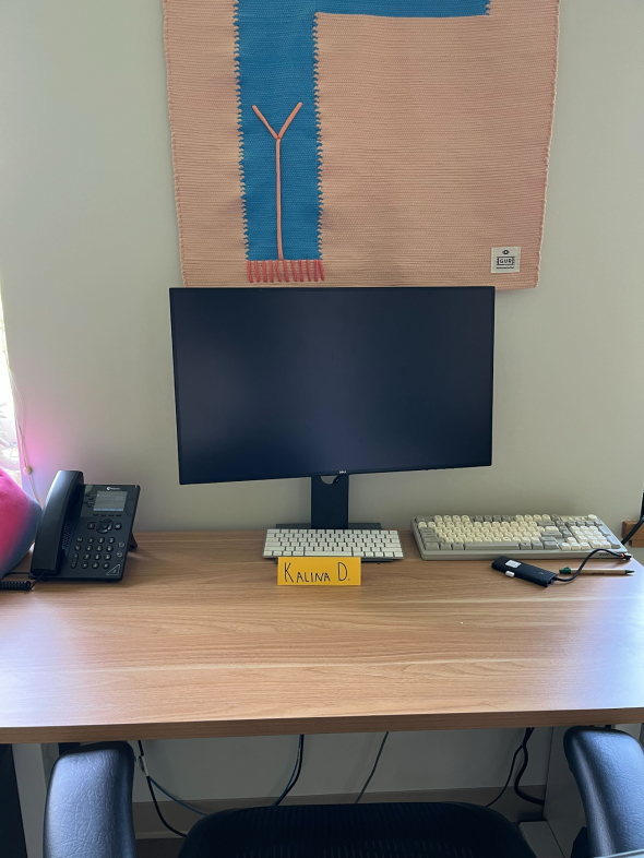 a picture of Kalina's desk at the FINN lab showing a black screen, a phone, and two keyboards