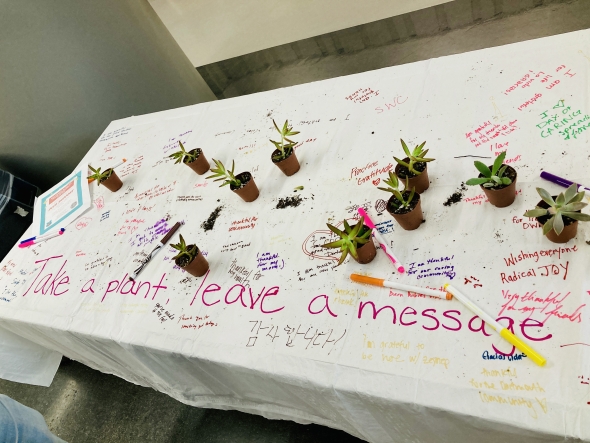 table cloth with encouraging messages written on it, and with succulents that people can take home