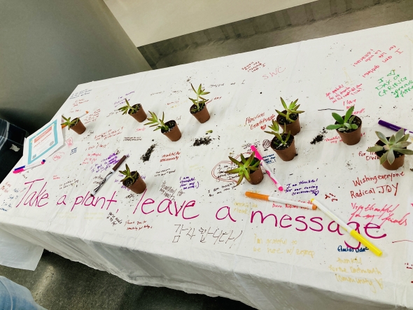 planting succulents, day of caring table cloth with encouraging messages written on it, and with succulents that people can take home
