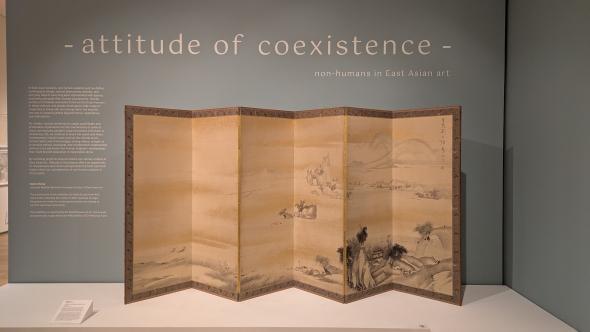 With a light blue background this is the focal wall of the Attitude of Coexistence exhibit which has a statement from the exhibit's curator.