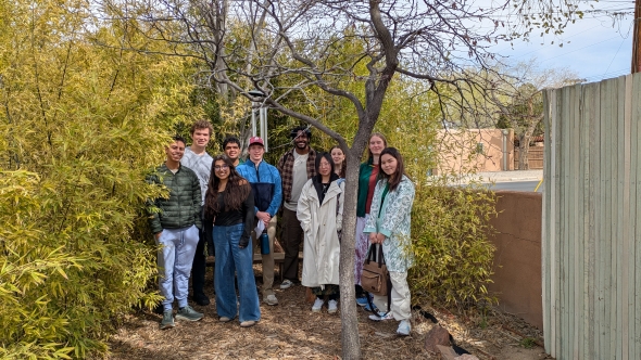 A group of Dartmouth students with a small tree in front of the group and bamboo behind and surrounding the group on the right side of the photo, with wind chimes in the center of the photo.