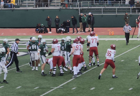 A mix of football players in green and red on a football field