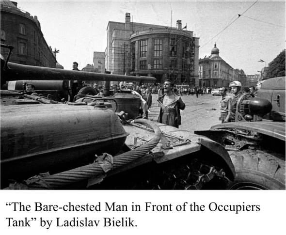 The image presented is of a man standing bare chested in Bratislava, the Slovak capital, in front of a Soviet Tank with the Comenius University in the background. 
