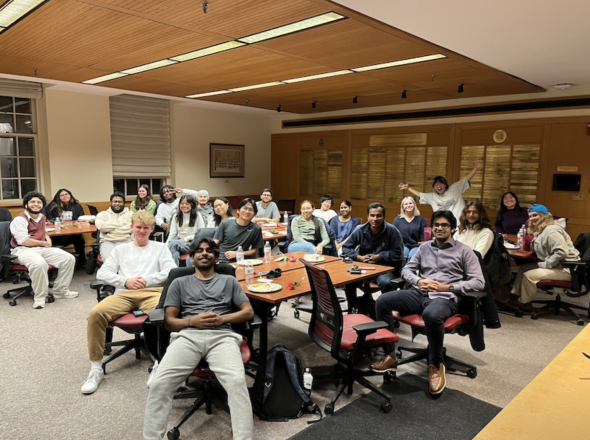 An image of students gathered in a room having dinner together