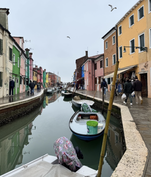 A small canal on Burano lined with brightly colored houses.