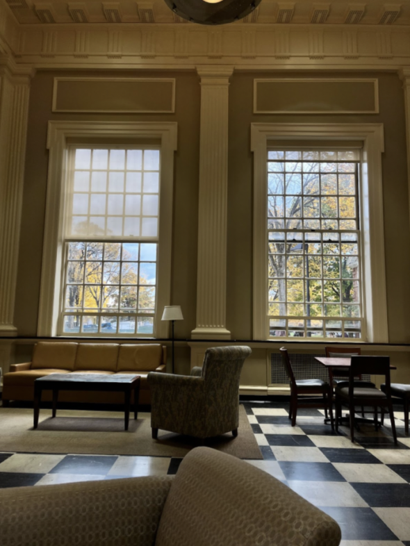 A view of a table, couch, and a few large chairs in Blobby on a sunny fall day. There are two large windows in the background.