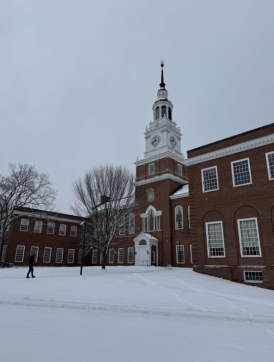 A picture of the dartmouth library from the side. The ground is covered in snow and the sky is foggy grey.