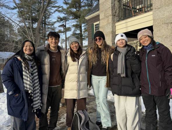 A group of students outside in the cold. The background is Occom pond and there is snow on the ground.