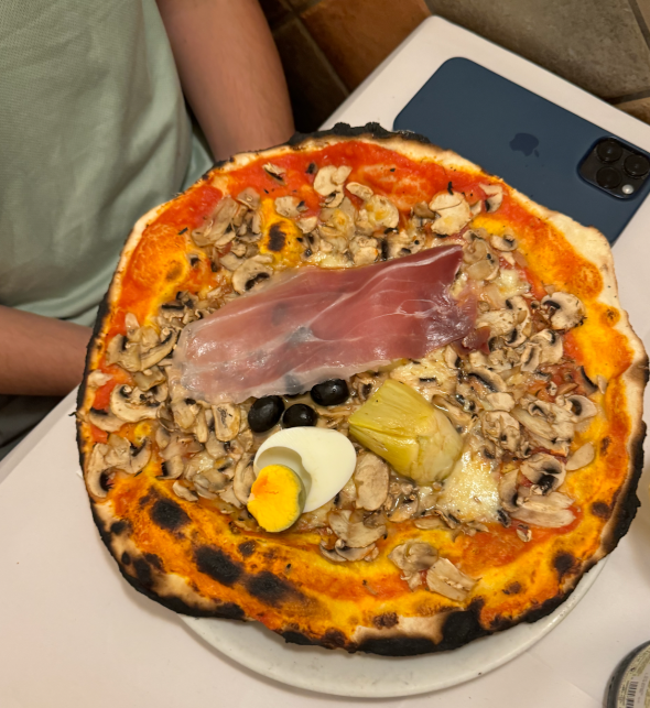 Pizza capricciosa, an Italian speciality made with mozzarella cheese, prosciutto, mushroom, artichoke and tomato.
