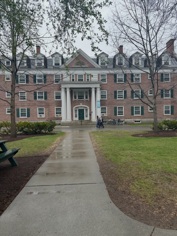 Picture of a brick building with many windows and pillars at the door.