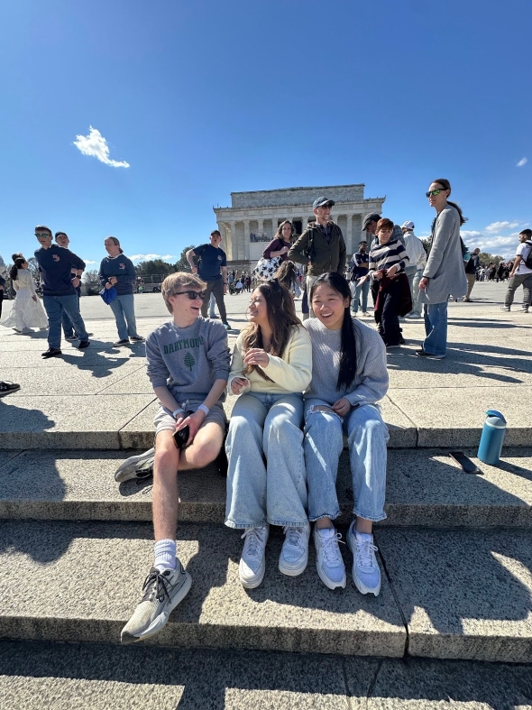 A .5 picture of three dartmouth students sitting on stone steps laughing. 