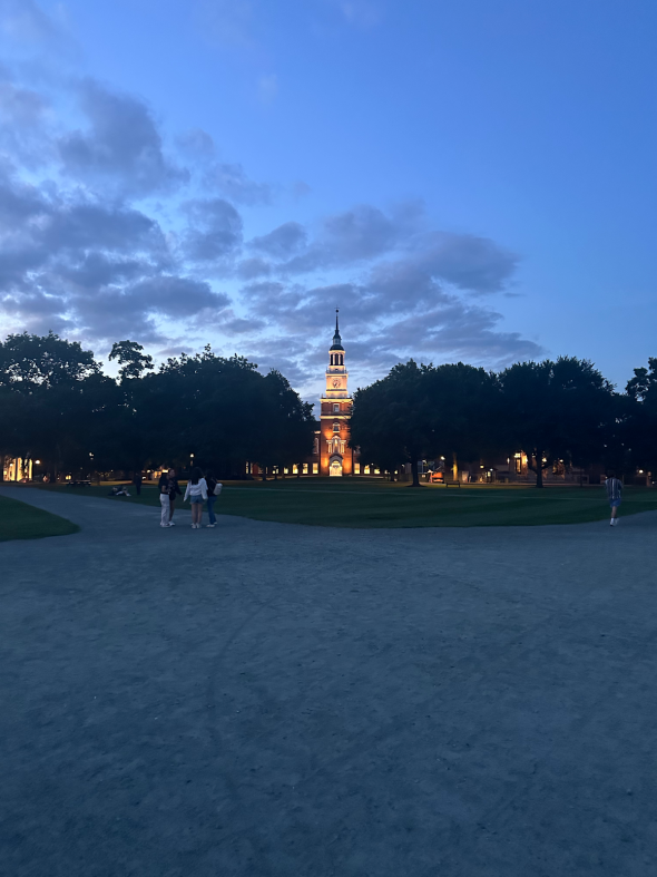 A picture of Baker-Berry library from the Green, lit up with clouds in the sky