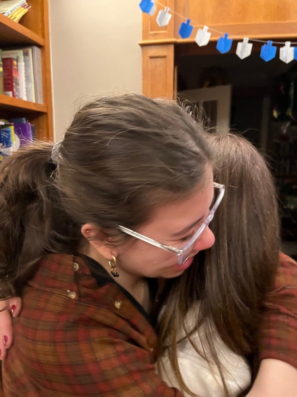 The camera is close to Serena as she hugs her mom. 