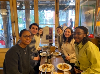 A picture of some people in the cohort at a traditional French lunch together with an enthusiastic photobomber in the background (very common here).