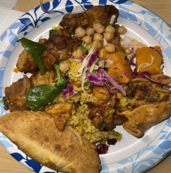 A plate of delicacies: rice, sweet potatoes, empanada, and curried chicken.